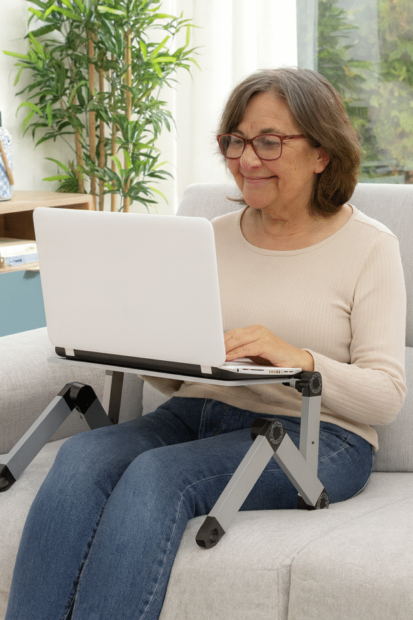 V0103206cMesa Multi-Posições Omnible InnovaGoods Mulher madura usando mesa ergonómica Omnible InnovaGoods para portátil em casa, confortável e segura