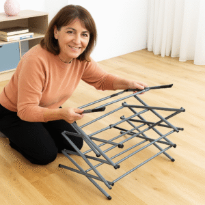 Mulher de aparência espanhola entre 50 e 60 anos montando estendal metálico rebatível Cloxy InnovaGoods, mostrando sistema dobrável