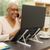 Mulher a trabalhar confortavelmente com suporte dobrável para portátil – ideal para postura e ergonomia.