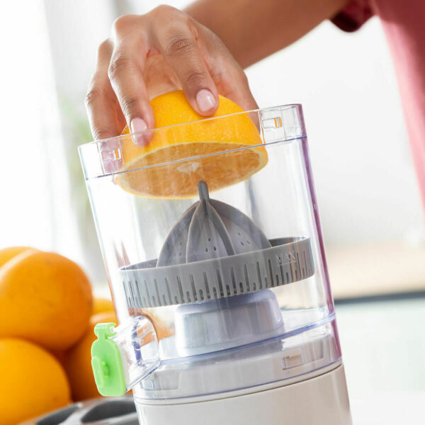 Espremedor Juisso em uso com laranja fresca Pessoa utilizando o espremedor Juisso para extrair sumo de laranja