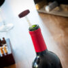 Garrafa de vinho com rolha e copo ao lado, acessório de vinho InnovaGoods elegante e prático