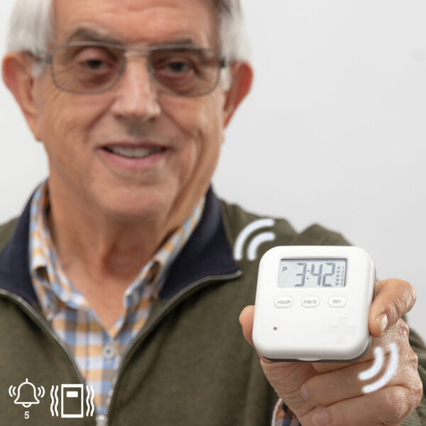 Alarme Digital com Caixa de Comprimidos – Lembrete para Idosos Idoso segurando alarme digital portátil com caixa de comprimidos, mostrando o visor e o horário definido.