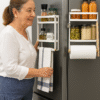 V0103239Prateleira Organizadora Magnética MagoRac InnovaGoods Mulher em frente a uma Prateleira Organizadora Magnética MagoRac InnovaGoods – Organização e Versatilidade para a Cozinha