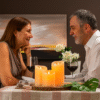 Casal maduro desfrutando de um jantar romântico com velas LED multicolor InnovaGoods, criando um ambiente aconchegante e seguro