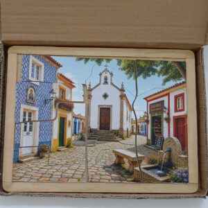 Puzzle artesanal Novoidoso com ilustração de uma aldeia portuguesa, montado numa moldura de madeira.
